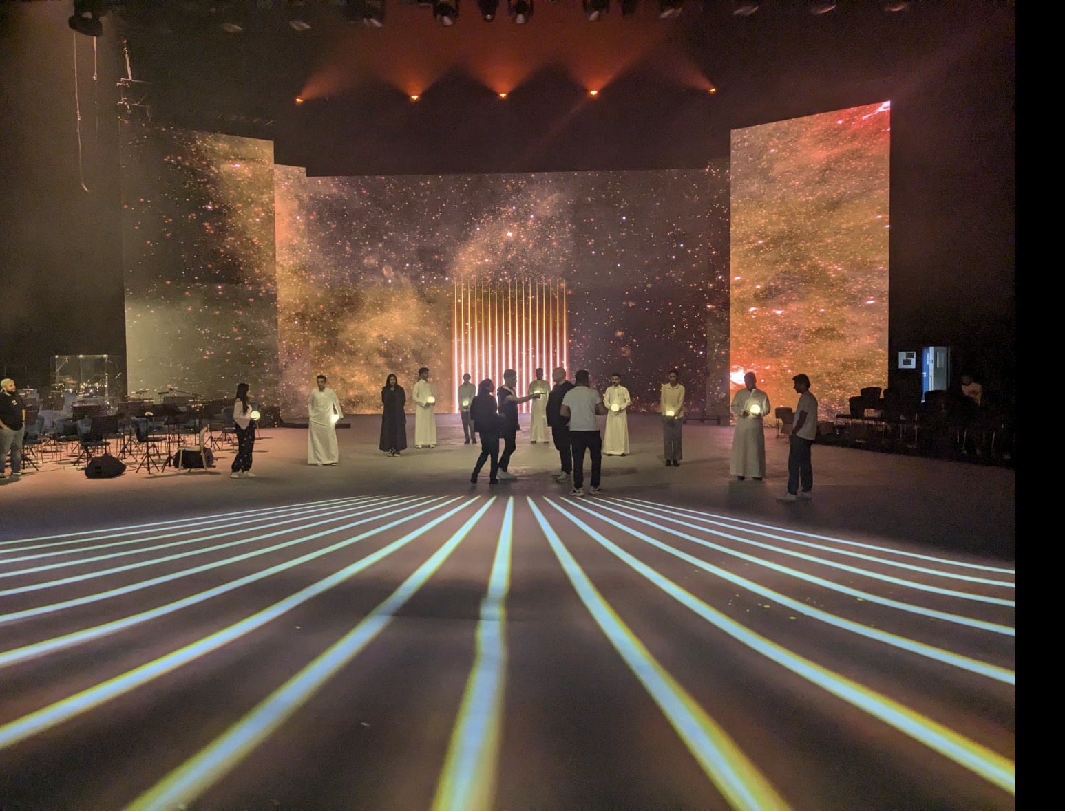 Rehearsal with performers in front of the cosmic backdrop